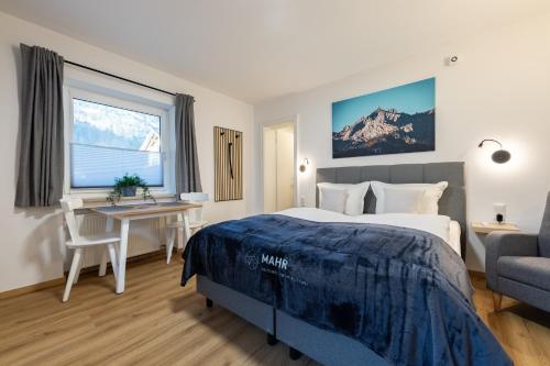 ein Schlafzimmer mit einem Bett, einem Schreibtisch und einer Couch in der Unterkunft Heu22 Heukammerl in Farchant