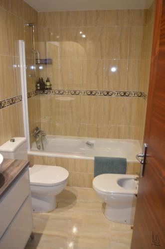 a bathroom with a toilet and a tub and a sink at JayjAstur in Cangas de Onís