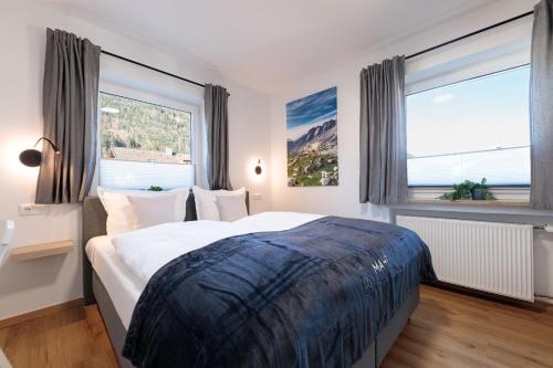 a bedroom with a large bed and large windows at Heu22 Herbstgold in Farchant