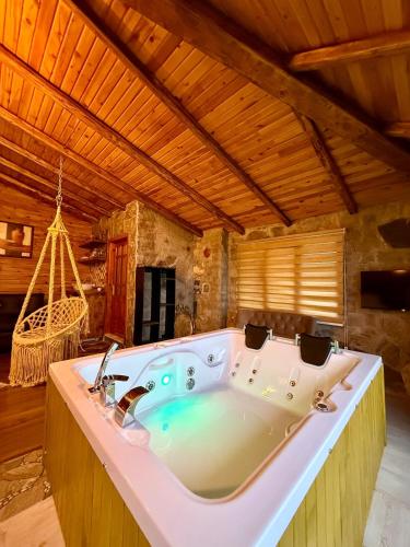 a large bath tub in a room with a hammock at İsgobya Dağ Evleri 108 in Macka