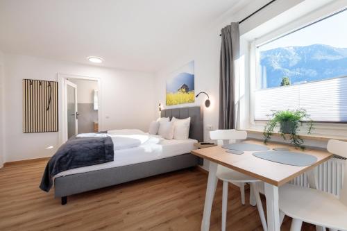 a bedroom with a bed and a desk and a window at Heu22 Frühlingserwachen in Farchant