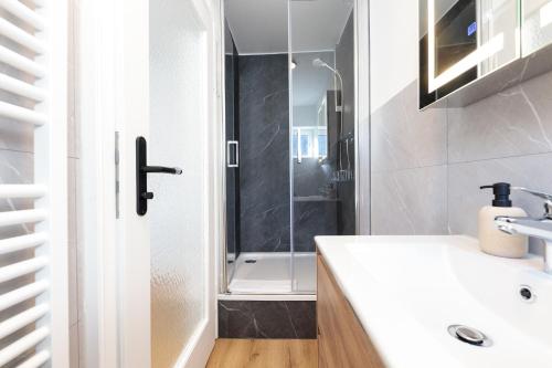 a bathroom with a shower and a white sink at Heu22 Frühlingserwachen in Farchant