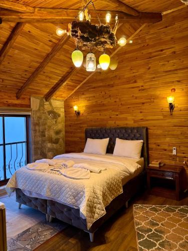 a bedroom with a bed in a room with wooden walls at İsgobya Dağ Evleri 108 in Macka
