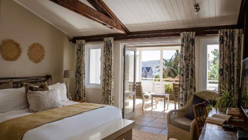 una camera da letto con un letto, un tavolo e una sedia di The Lofts Boutique Hotel a Knysna