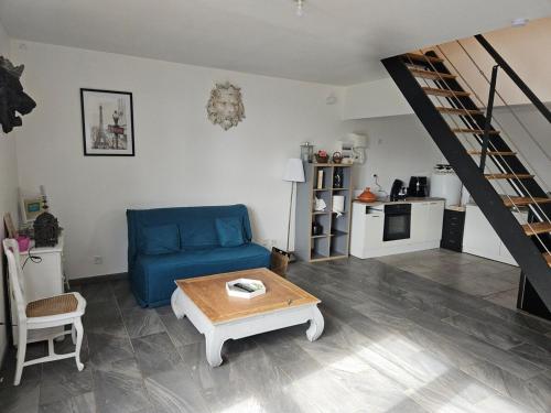 ein Wohnzimmer mit einem blauen Sofa und einem Tisch in der Unterkunft house in a farmhouse in Sains-lès-Fressin
