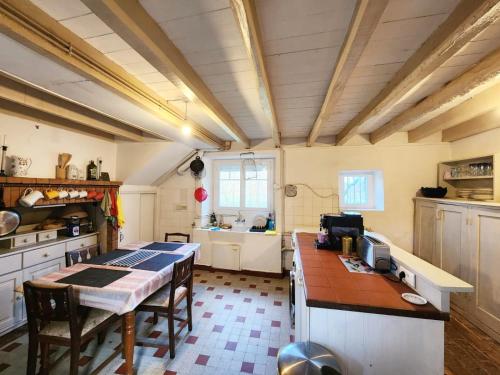 eine Küche mit Tisch und eine Küche mit Spüle in der Unterkunft Demeure périgourdine, prairies et accès rivière in Cherveix-Cubas