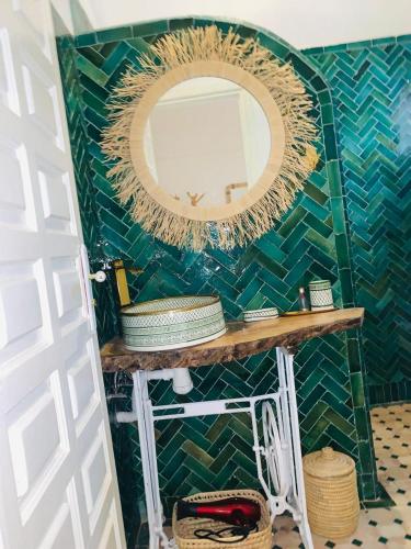 a bathroom with a mirror on a green tiled wall at Riad Kechin Beldi in Marrakesh
