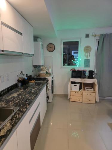 a kitchen with white cabinets and a counter top at Peperina 2 villa Carlos paz in Villa Carlos Paz
