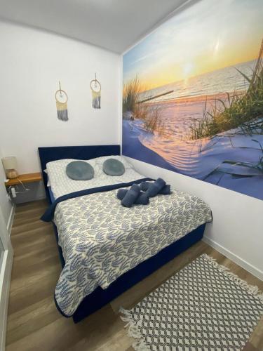 a bedroom with a bed and a painting on the wall at Apartament SUNNY Rusinowo in Rusinowo
