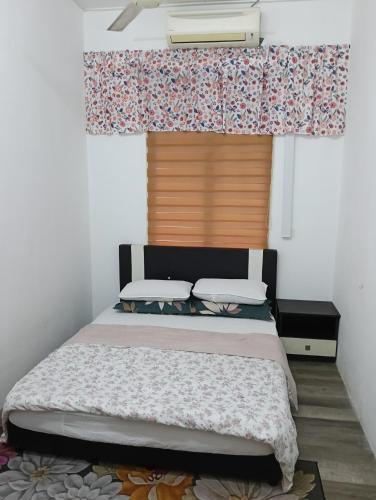 a bedroom with a bed and a window with curtains at Shayus Homestay in Kampong Alor