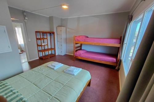 a bedroom with two bunk beds with pink sheets at Guanaco Hostel in Puerto Madryn