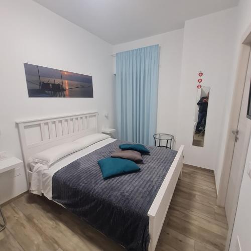 a bedroom with a bed with blue pillows on it at B&B Battisti59 in Vieste