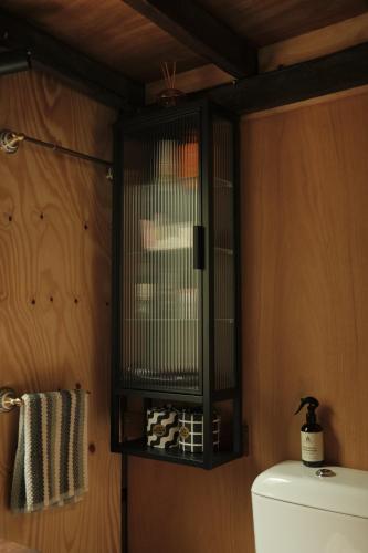 a black bird cage above a toilet in a bathroom at Rancho Relaxo Tiny House - in town sanctuary in Margaret River Town