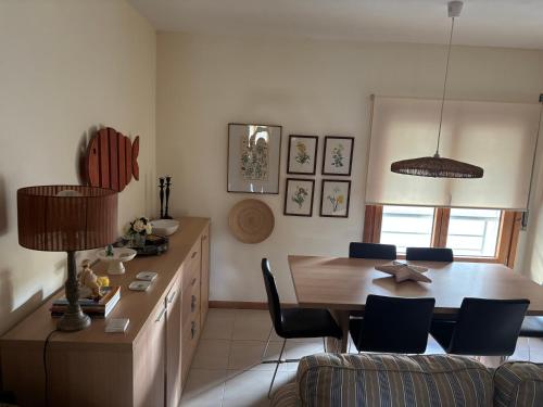 a kitchen with a table and a dining room at Lua do Mar - T2 - Piscina - Fte ao Mar- Central in Nazaré