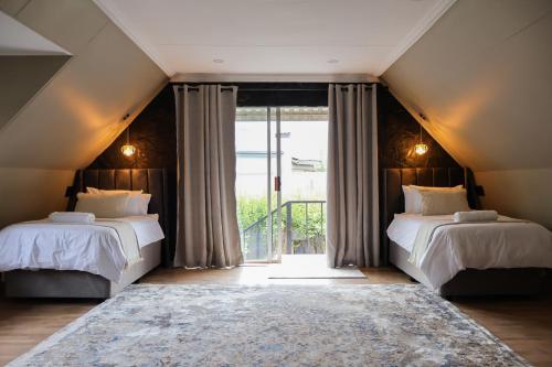 a bedroom with two beds and a large window at Fossil Lane in Clarens