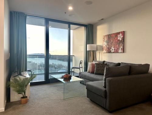 a living room with a couch and a large window at Lake Views Belconnen apartment with 2 bedrooms and sofa bed in Belconnen