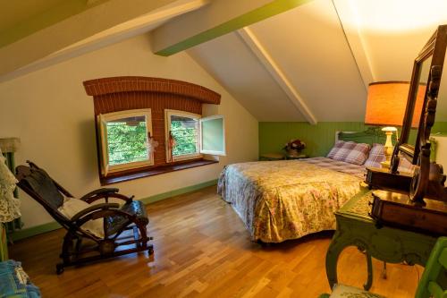 een slaapkamer met een bed, een stoel en een raam bij Villa Claudia in Montecatini Terme