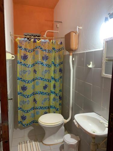 een badkamer met toilet en douchegordijn bij Pousada Casa do Josef in Canoa Quebrada