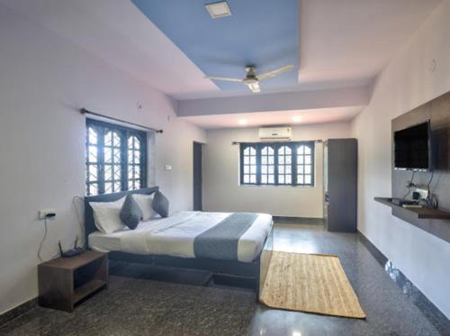 a bedroom with a bed and a flat screen tv at Hotel White Calangute in Calangute