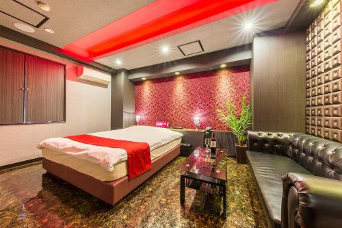 a bedroom with a bed and a couch in a room at ドンキーズジャングル千葉市店 in Chiba
