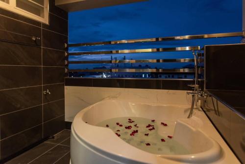 bagno con vasca e fiori di โรงแรมริเวอร์ ซิตี้ ปัตตานี a Ban Ru Sa Mi Lae