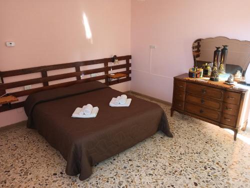 een slaapkamer met een bed met twee slippers erop bij La casa di Mascia in Roccasecca