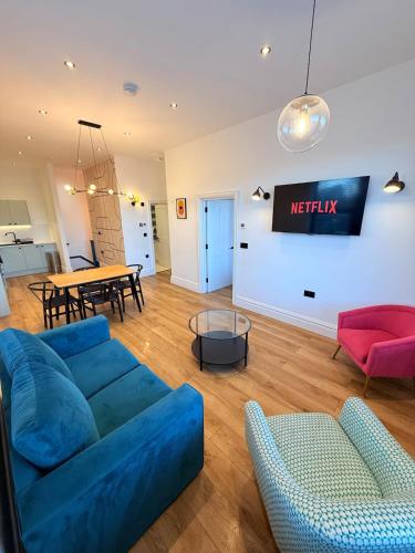 a living room with a blue couch and a table at Central - Free parking- Sleeps 6 - Stylish Apt in Bristol