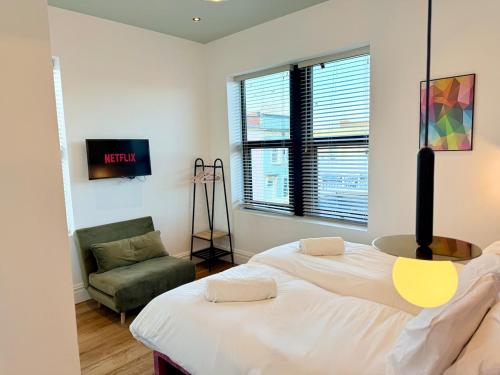 a bedroom with a large bed and a chair at Central - Free parking- Sleeps 6 - Stylish Apt in Bristol
