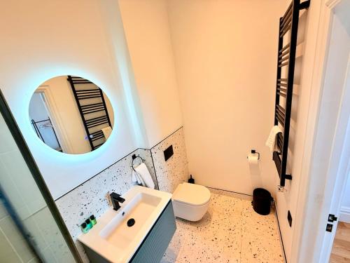 a bathroom with a sink and a toilet and a mirror at Central - Free parking- Sleeps 6 - Stylish Apt in Bristol