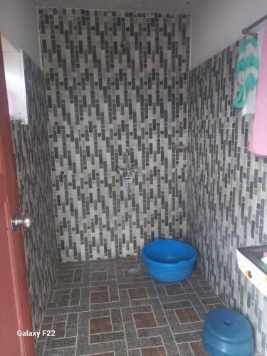 a bathroom with a blue toilet and a tiled floor at Kimche Guest House in Astam
