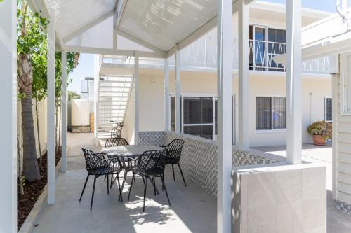 a patio with chairs and a table on a house at Esplanade Apartments at West Beach in Adelaide