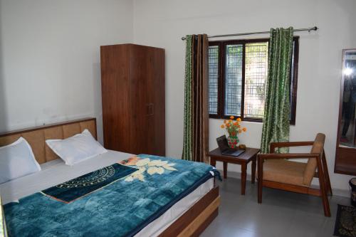 ein Schlafzimmer mit einem Bett, einem Stuhl und einem Fenster in der Unterkunft Rameshwari Homestay in Lansdowne