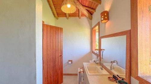 a bathroom with a sink and a mirror at Vila Budião - Corumbau in Corumbau