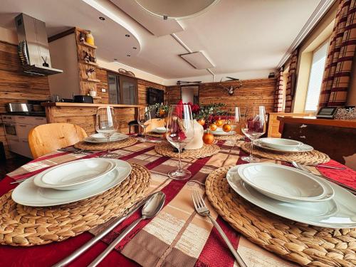 een eettafel met borden en wijnglazen bij ALPENLOFT Gerlitzen Ski in - Ski out! in Kanzelhöhe