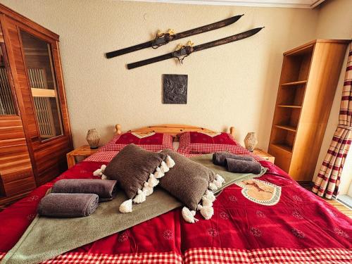 een slaapkamer met een rood bed met kussens erop bij ALPENLOFT Gerlitzen Ski in - Ski out! in Kanzelhöhe