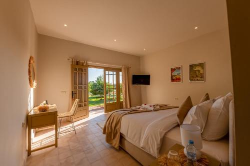 a bedroom with a bed and a table and a window at Villa Nour in Marrakesh