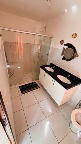 a bathroom with two sinks and a shower at Mansão suíça nos campos - Perto das praias in Aquiraz