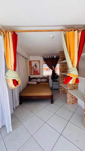 a room with a bed in a room with curtains at Mansão suíça nos campos - Perto das praias in Aquiraz