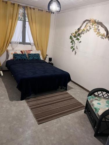 a bedroom with a bed with a blue comforter at Fleur de Canne in Saint-Benoît