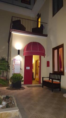 a room with a red door and a bench in a building at Villa Margherita in Cefalù
