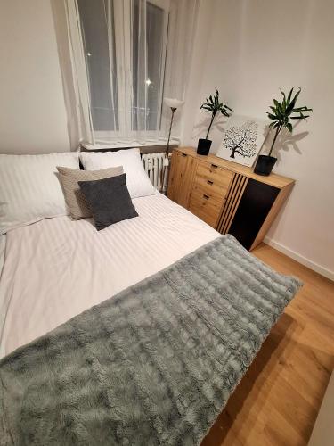a bedroom with a white bed with a gray blanket at Apartament Polna 21 in Kalisz