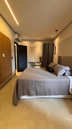 a bedroom with a large bed and a table at Smart Residence Moderno in Santarém