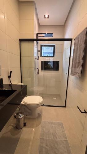 a bathroom with a toilet and a glass shower at Smart Residence Moderno in Santarém