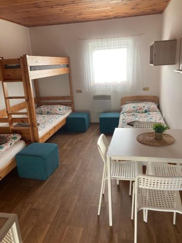 a room with two bunk beds and a table and chairs at Penzion Hevera in Kuchařovice