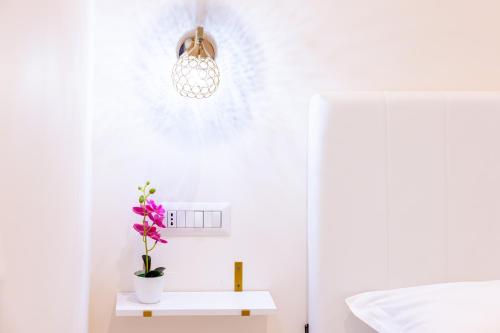 ein weißes Zimmer mit einer Topfpflanze auf einem Tisch in der Unterkunft Ginevra Luxury Taormina in Taormina