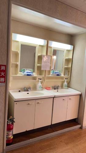 a bathroom with two sinks and a mirror at 苗場ウッドインだいまる in Yuzawa
