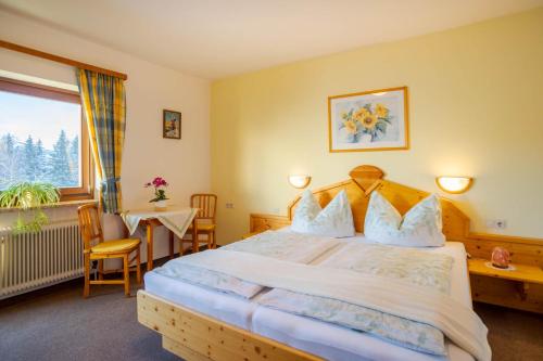 a bedroom with a bed and a table and a window at Bio Bauernhof Holzegghof in Zell am See in Erlberg