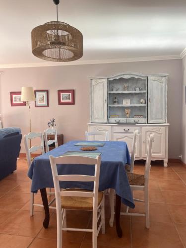 ein Esszimmer mit einem blauen Tisch und Stühlen in der Unterkunft Maison chaleureuse in Mézos