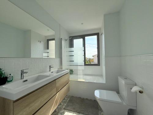 a white bathroom with a sink and a toilet at The White House in Calafell