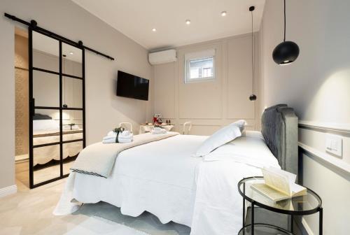 een slaapkamer met een groot wit bed en een tv bij Residence Briona in Domodossola